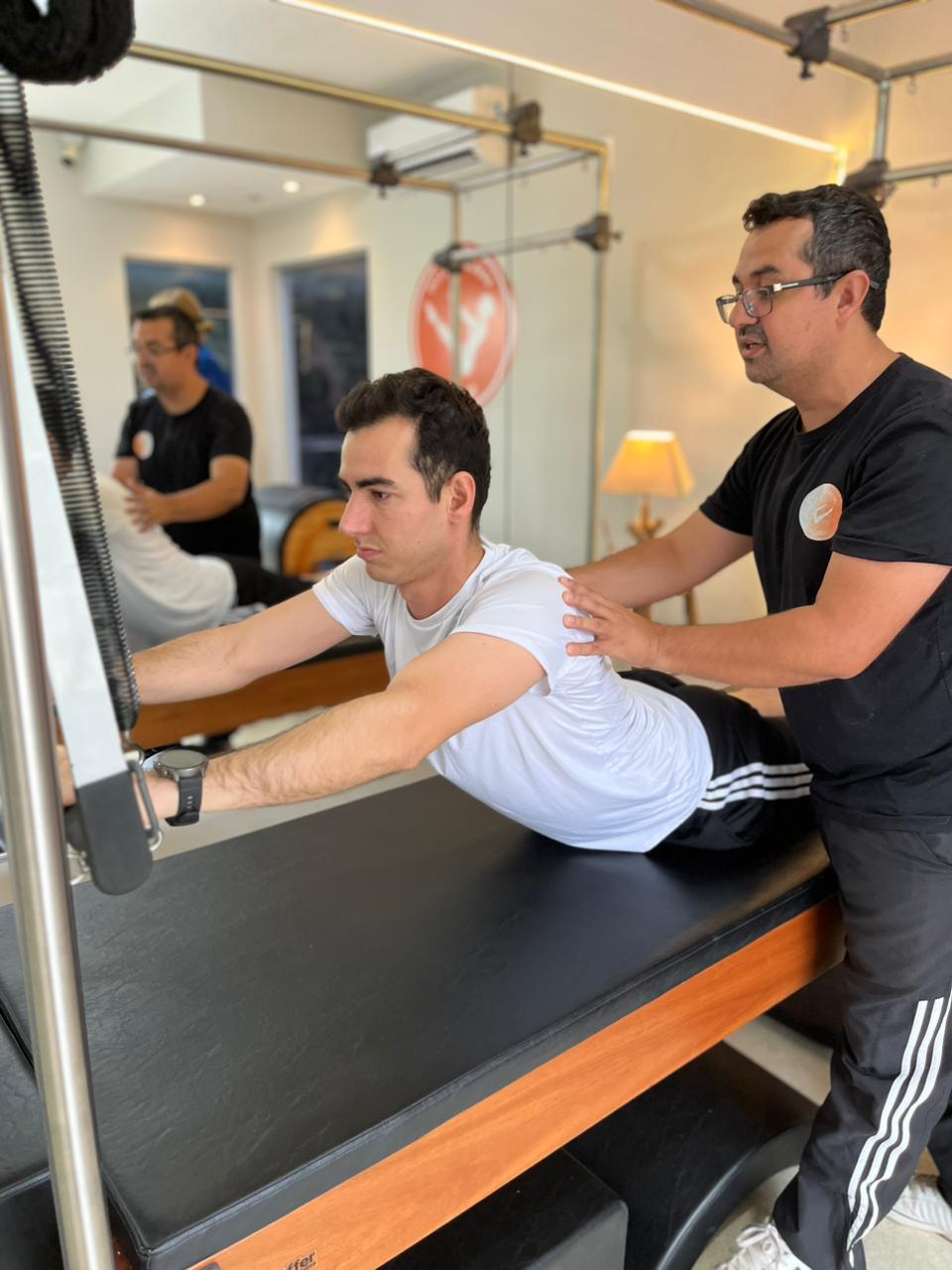 Fellipe Vasconcellos orientando aluno durante exercício no Reformer no Vasconcellos Studio